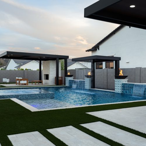 Modern pool with negative edge spa and covered outdoor kitchen on 205th Way in Queen Creek, AZ by Envy Pools
