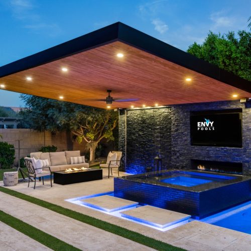 Modern pool with raised spa, water slide and cantilever pergola on Raven Court in Queen Creek, AZ by Envy Pools