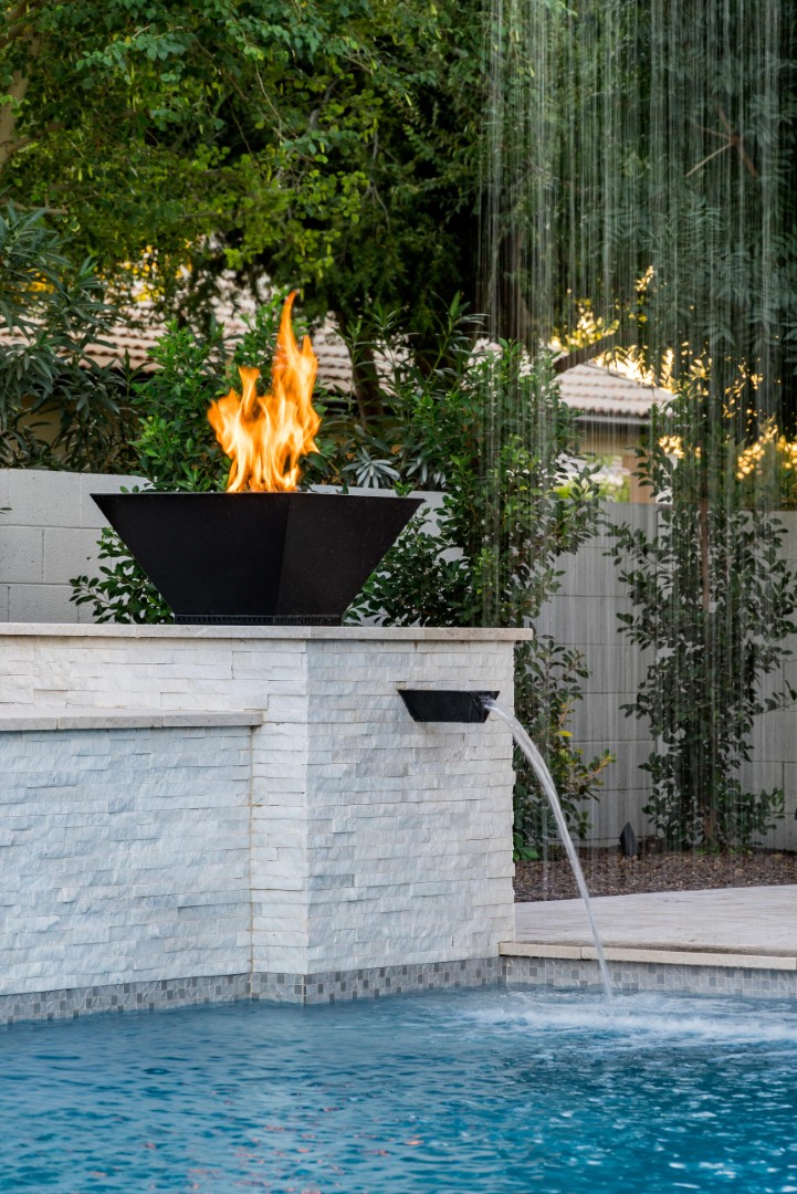 Custom pool with fire bowls, glass curtain waterfall, and outdoor kitchen in Queen Creek, AZ by Envy Pools