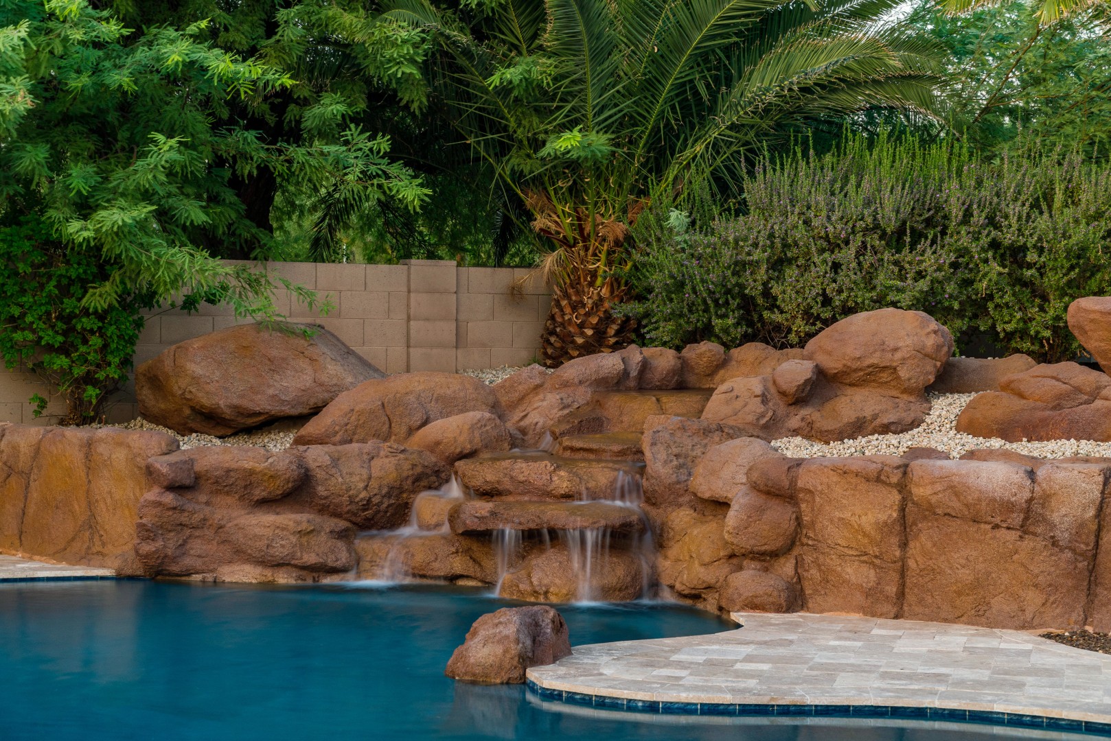 Custom freeform pool and boulder waterfall on Lobo Avenue in Mesa, AZ by Envy Pools