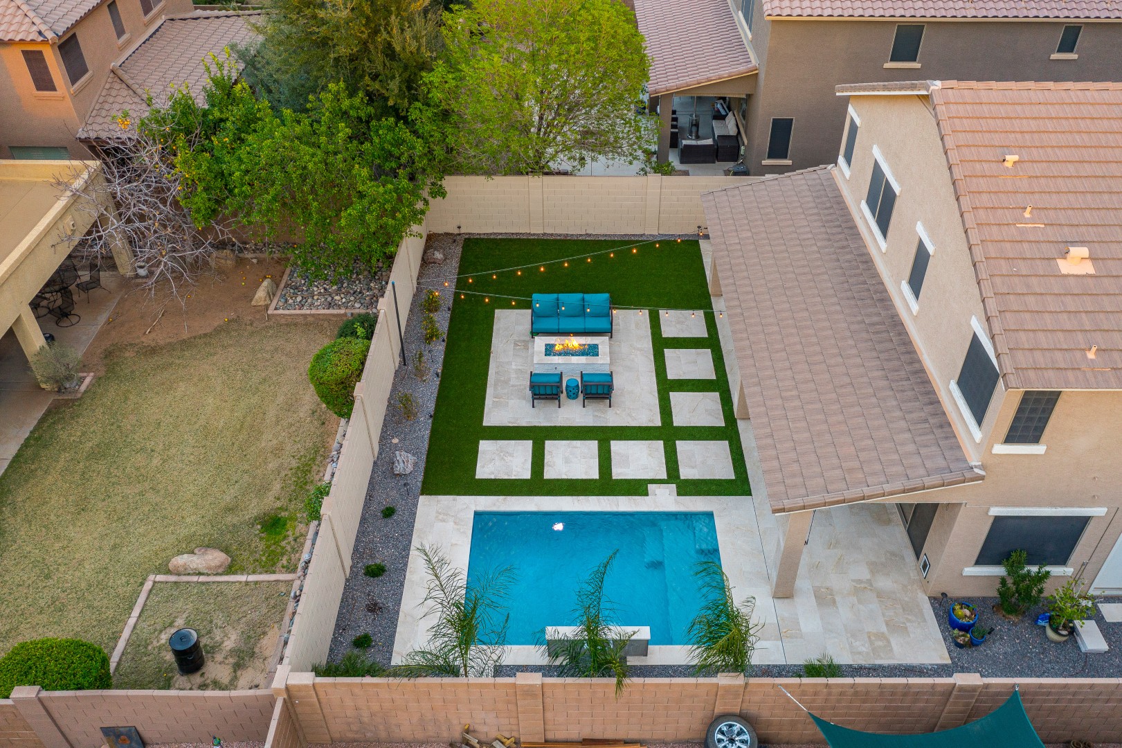 Custom rectangular pool with fish-scale tile water feature and fire pit in Gilbert, AZ by Envy Pools