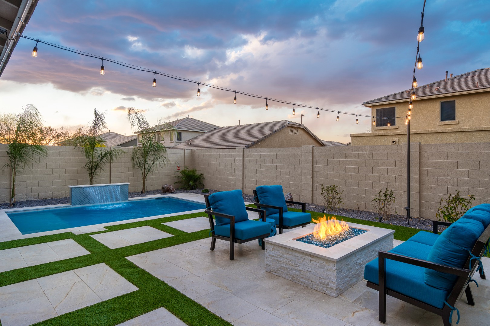 Custom rectangular pool with fish-scale tile water feature and fire pit in Gilbert, AZ by Envy Pools