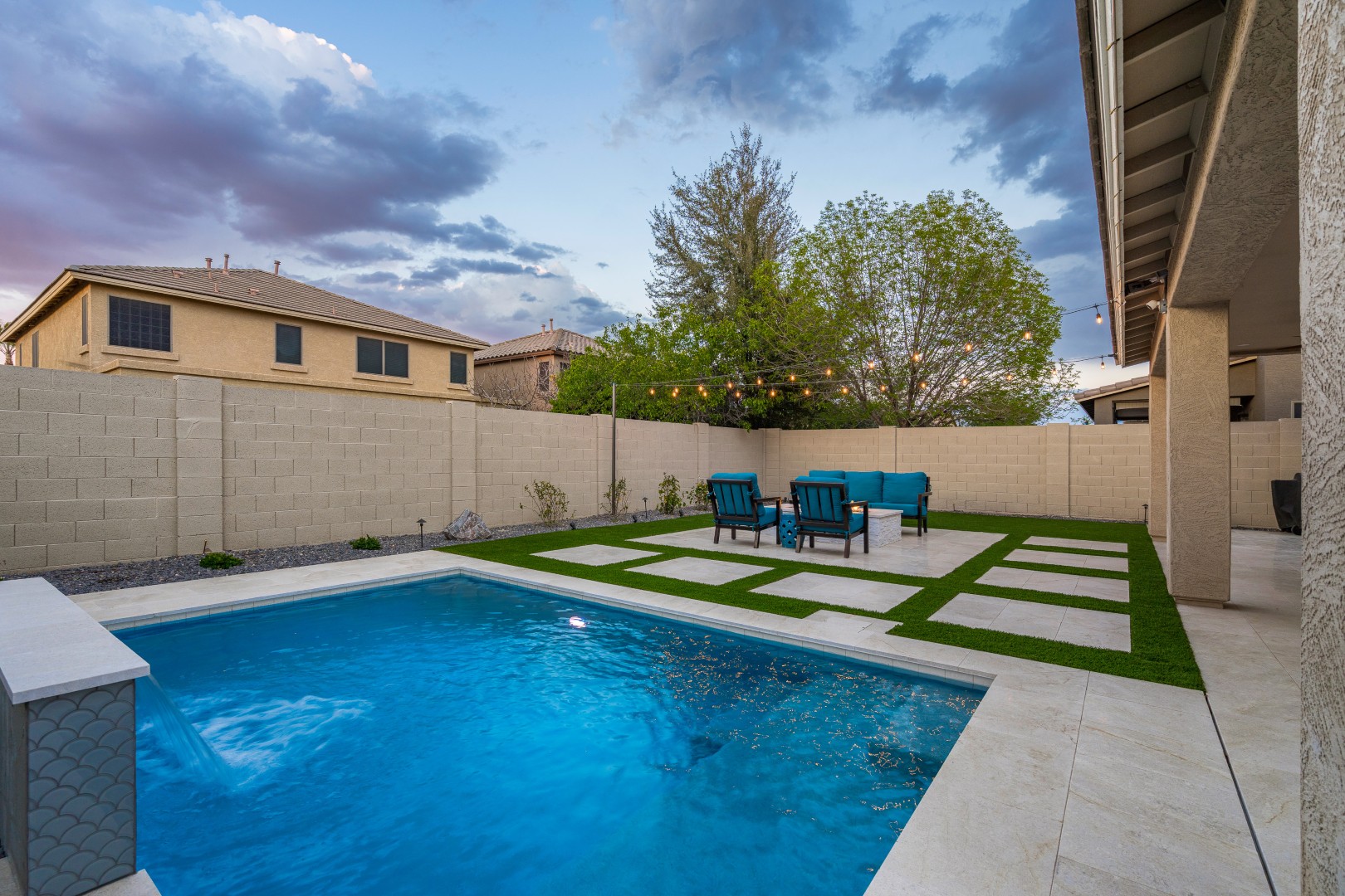 Custom rectangular pool with fish-scale tile water feature and fire pit in Gilbert, AZ by Envy Pools