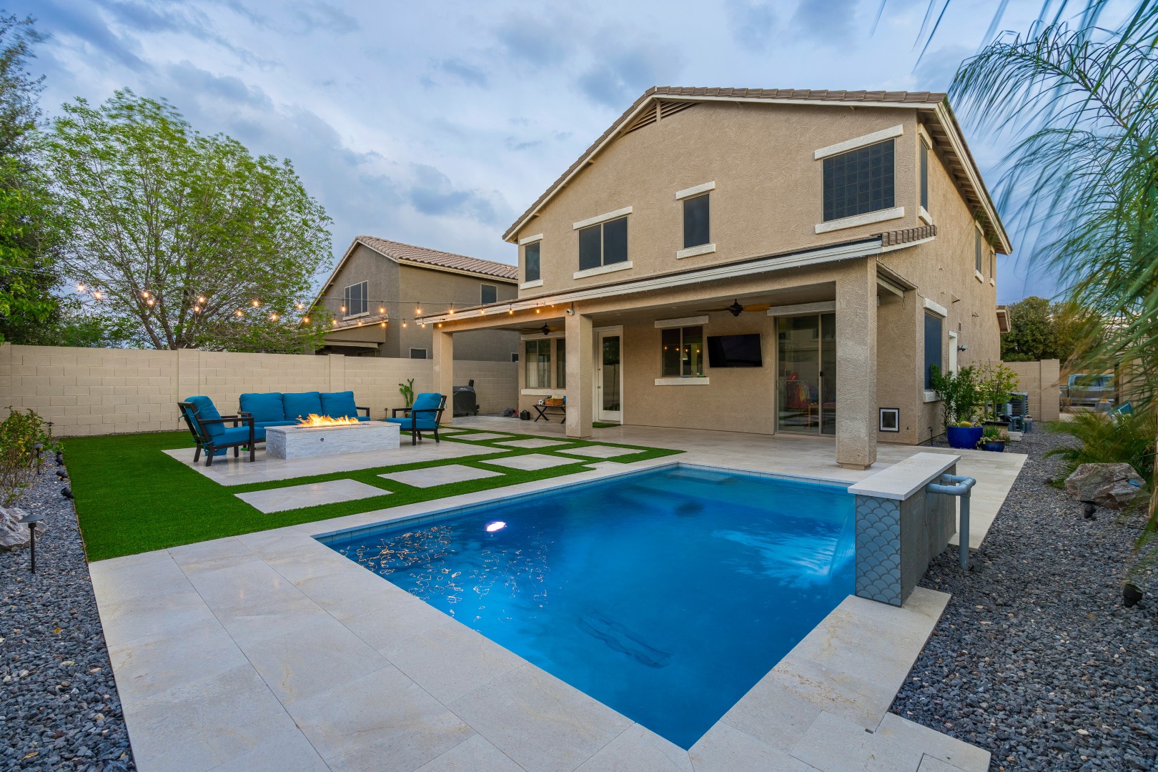 Custom rectangular pool with fish-scale tile water feature and fire pit in Gilbert, AZ by Envy Pools