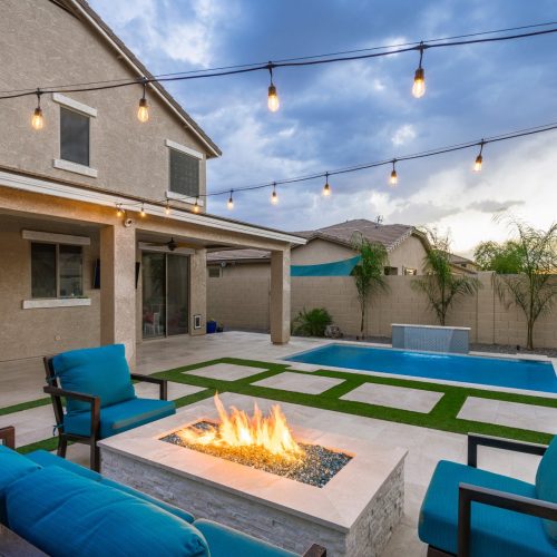 Custom rectangular pool with fish-scale tile water feature and fire pit in Gilbert, AZ by Envy Pools