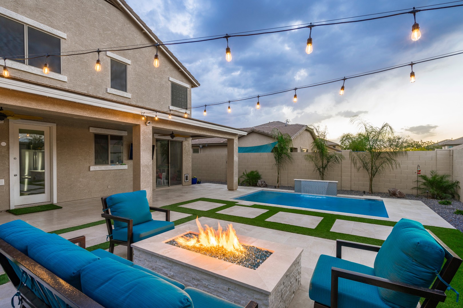 Custom rectangular pool with fish-scale tile water feature and fire pit in Gilbert, AZ by Envy Pools