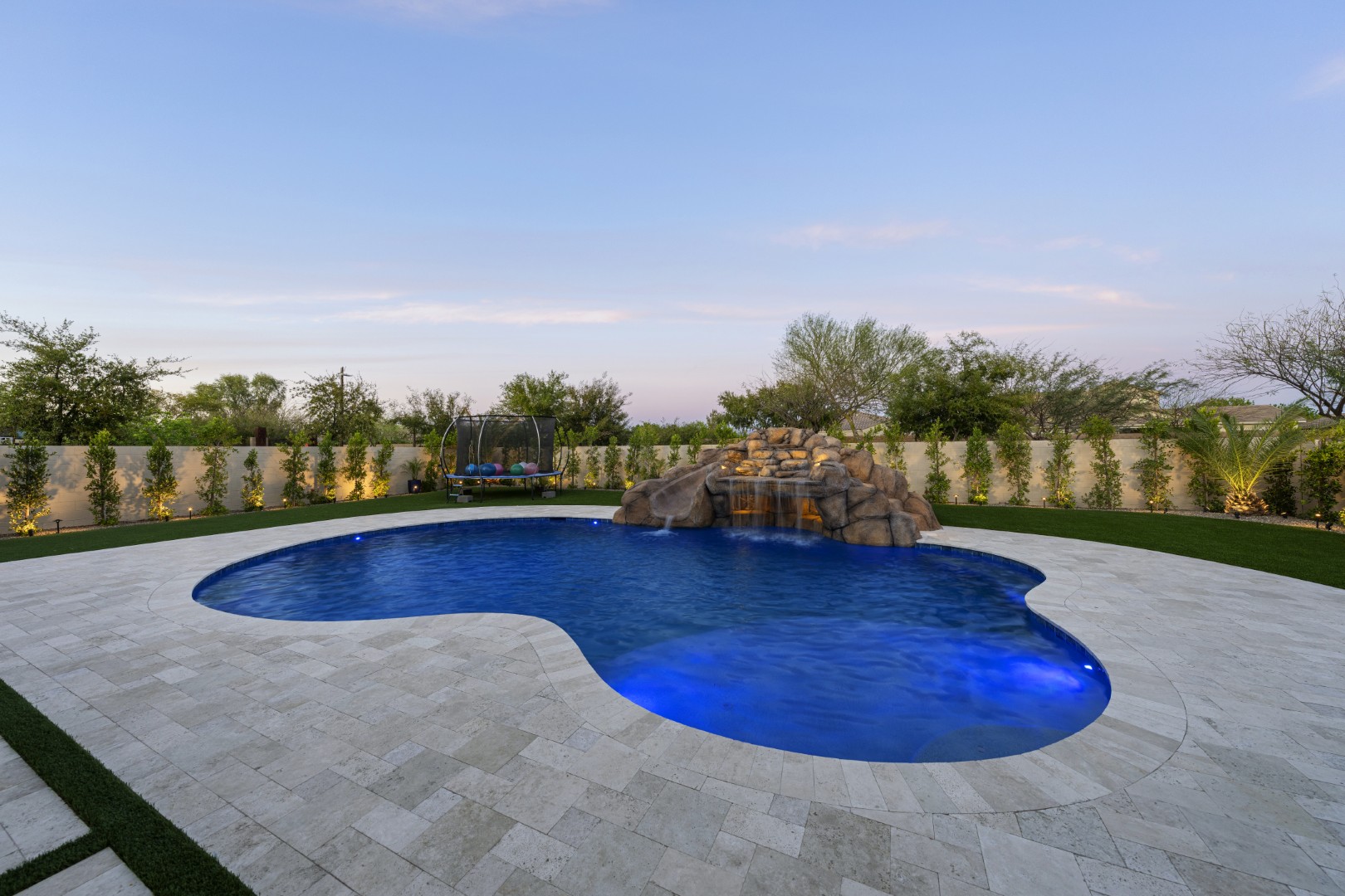 Custom pool with rock waterfall on Quantum Way in Mesa, AZ by Envy Pools