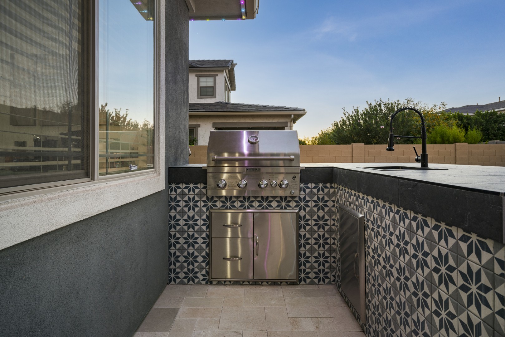 Custom pool with fire and water feature wall, raised spa, and outdoor kitchen in Gilbert, AZ by Envy Pools