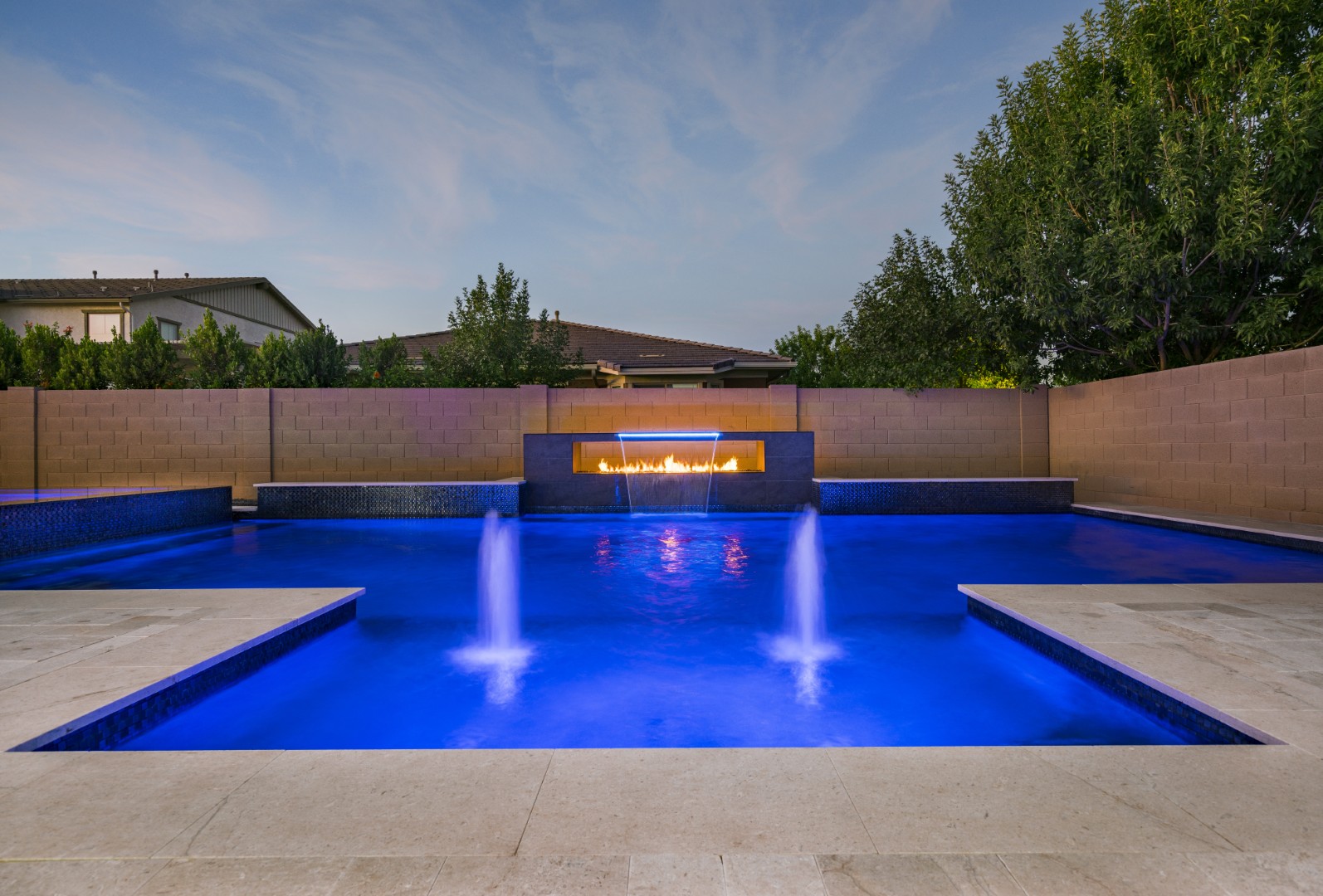 Custom pool with fire and water feature wall, raised spa, and outdoor kitchen in Gilbert, AZ by Envy Pools