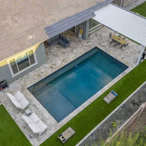 Modern rectangular pool with pergola-covered patio in Mesa, AZ by Envy Pools