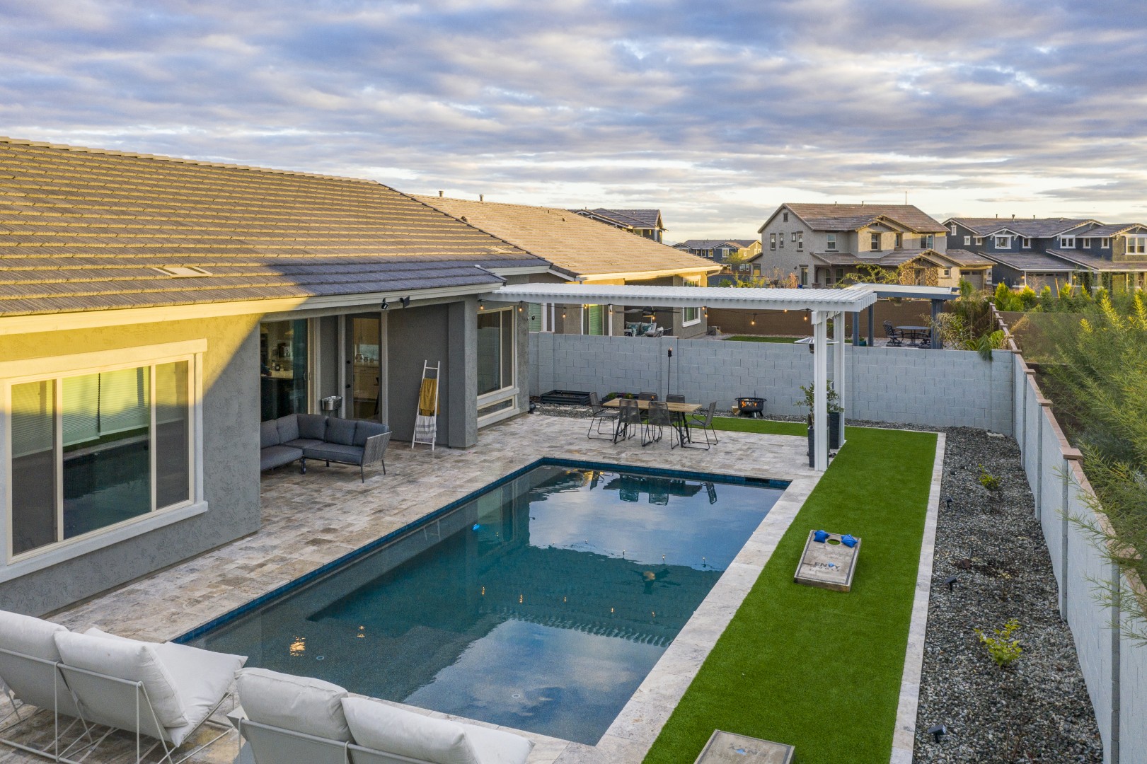 Modern rectangular pool with pergola-covered patio in Mesa, AZ by Envy Pools