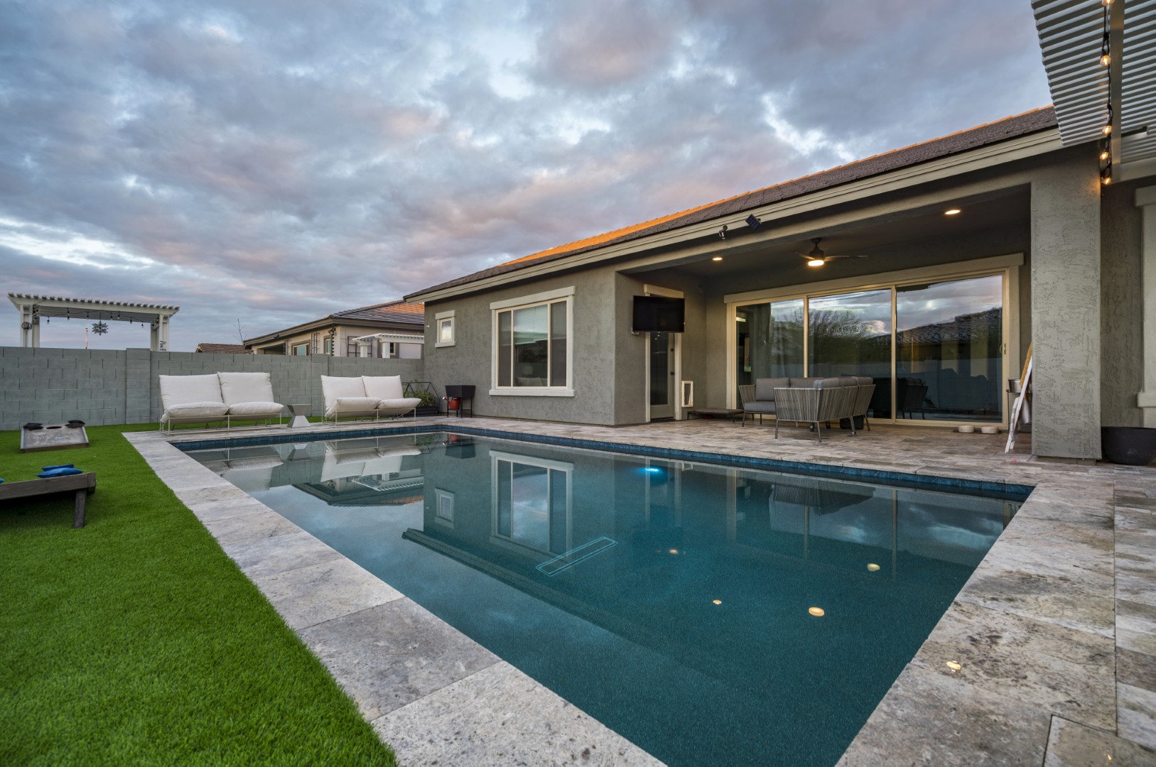 Modern rectangular pool with pergola-covered patio in Mesa, AZ by Envy Pools