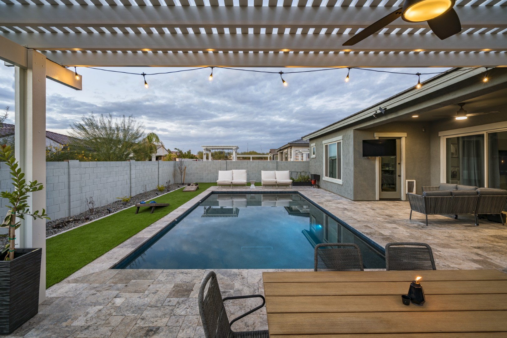 Modern rectangular pool with pergola-covered patio in Mesa, AZ by Envy Pools