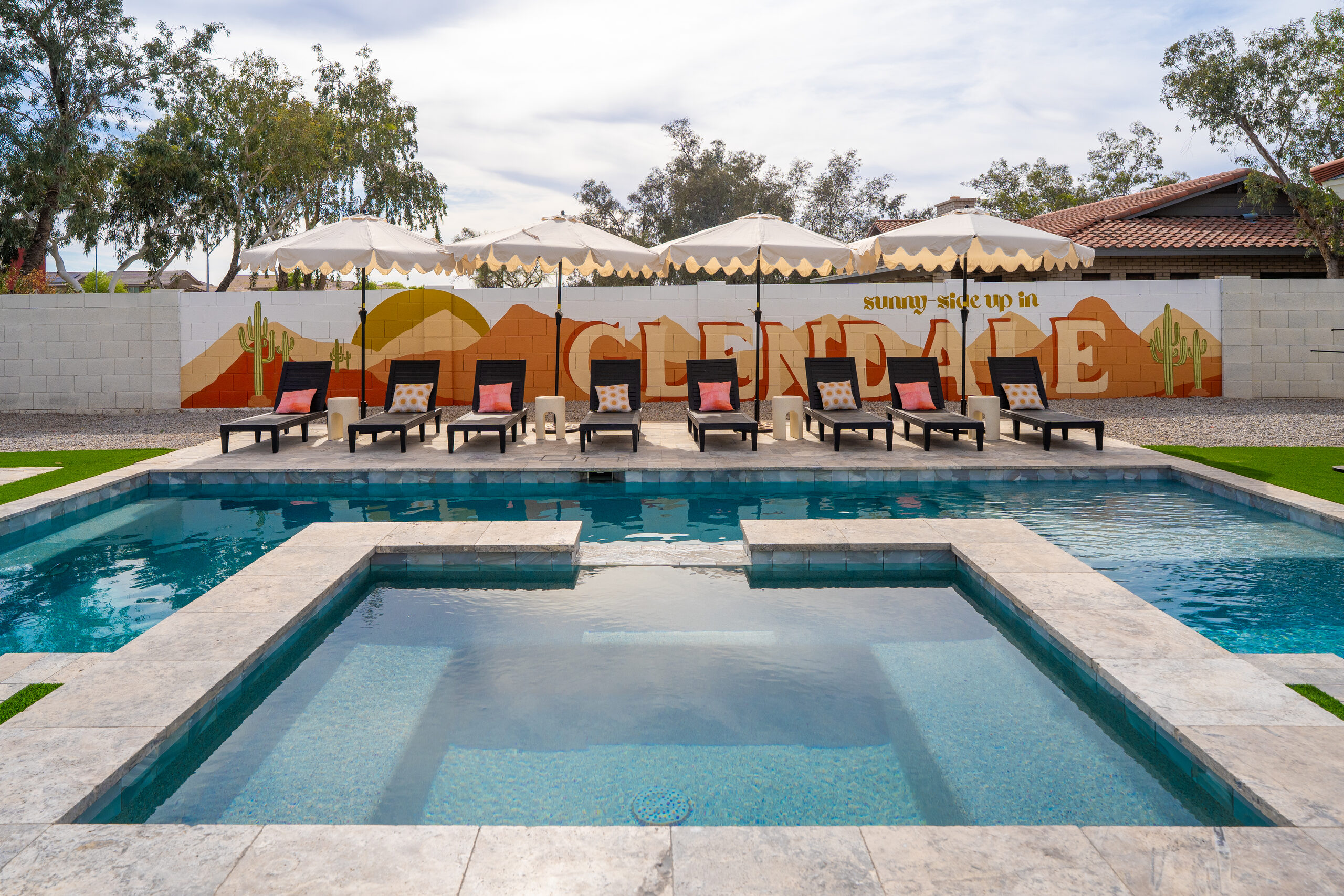 Rectangular pool and lounge seating with a painted mural wall in Glendale, AZ