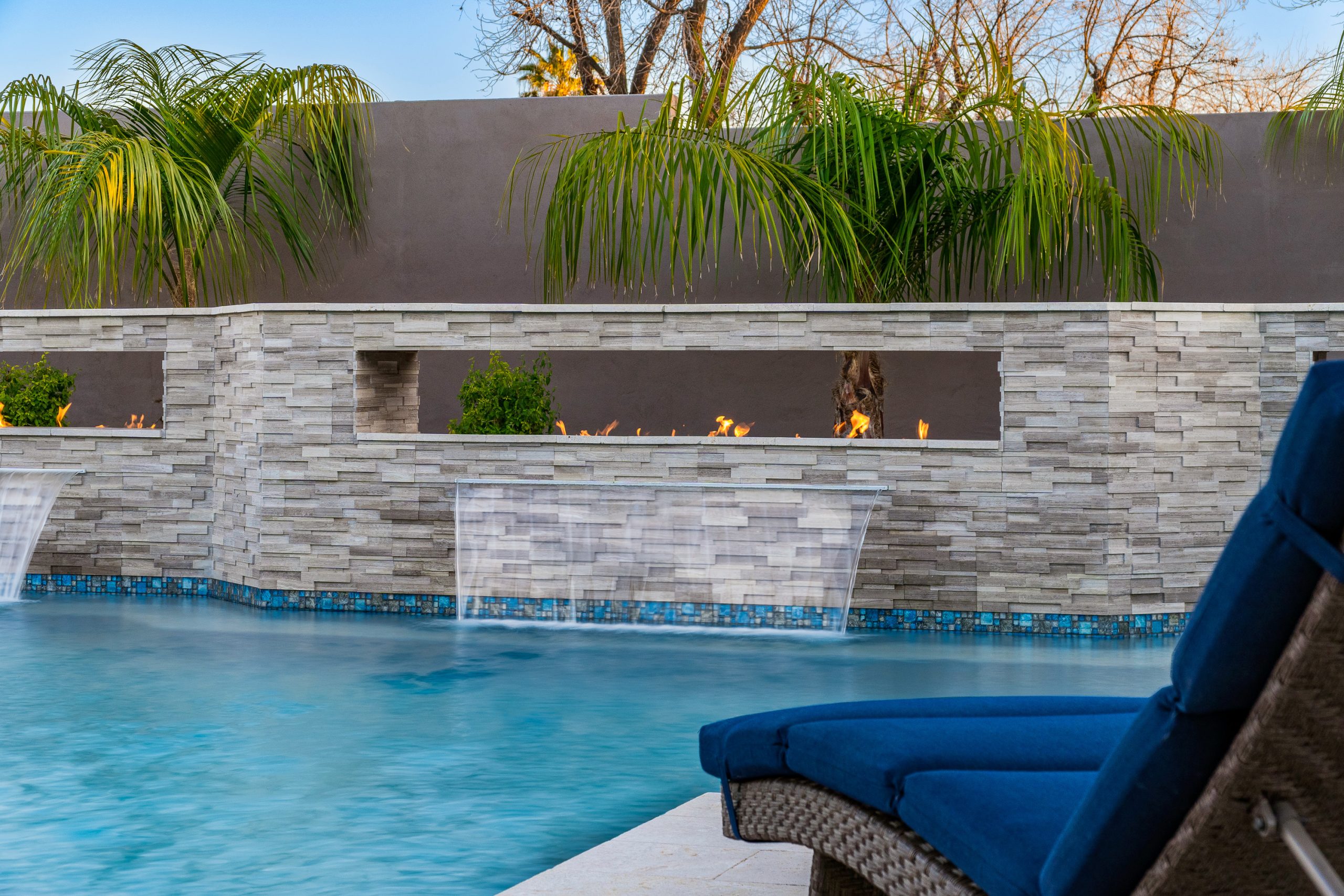 Linear fire feature above sheer descents on a pool wall in Queen Creek, AZ