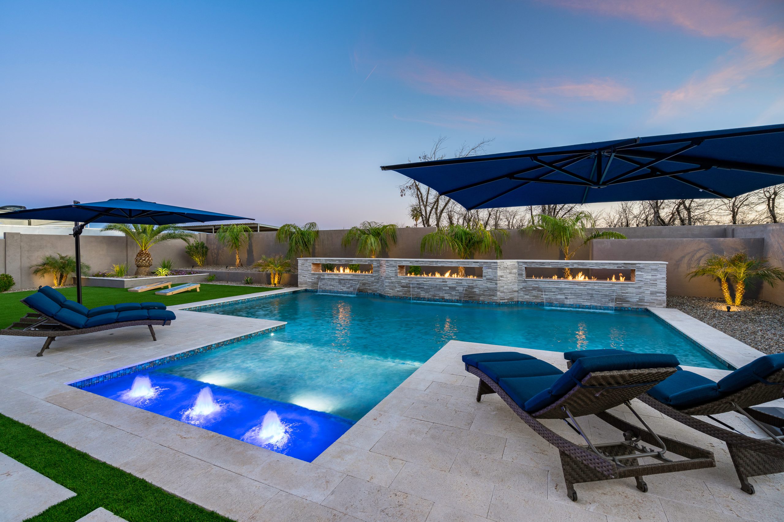 Rectangular pool with fire and water wall at dusk in Queen Creek, AZ