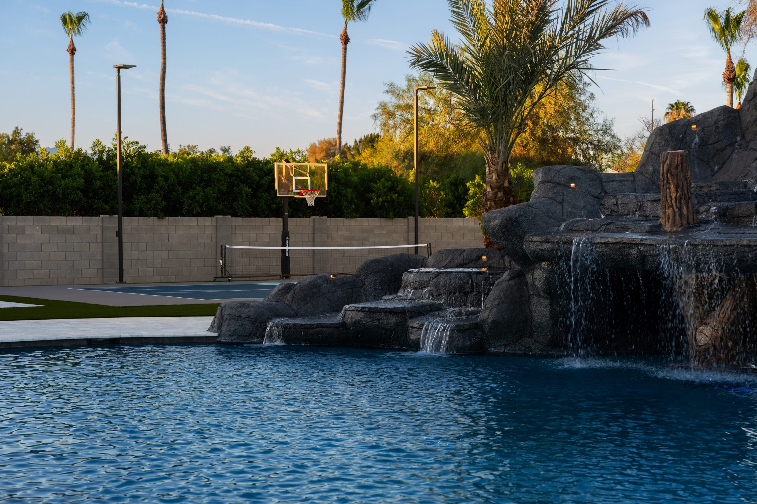 Backyard sport court beside a rock waterfall pool in Gilbert, AZ