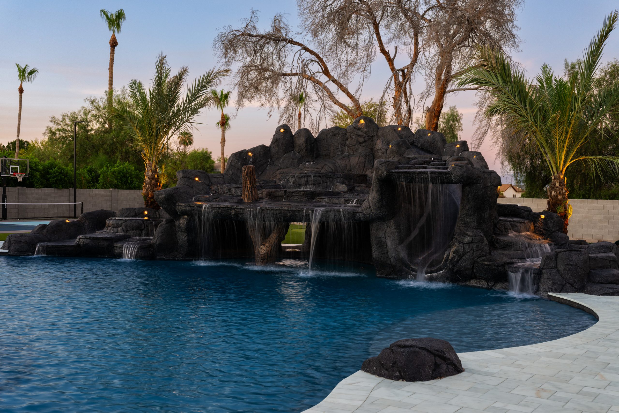 Multi-tier rock waterfall and mature palms in a Gilbert, AZ backyard