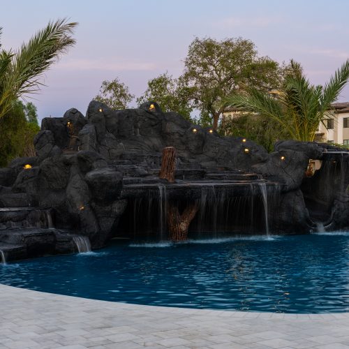 Wide view of a custom freeform pool and rock grotto in Gilbert, AZ