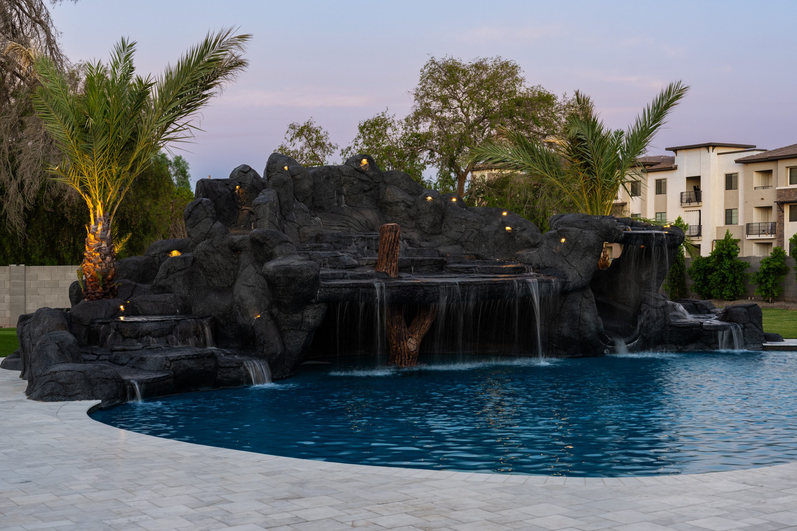 Wide view of a custom freeform pool and rock grotto in Gilbert, AZ