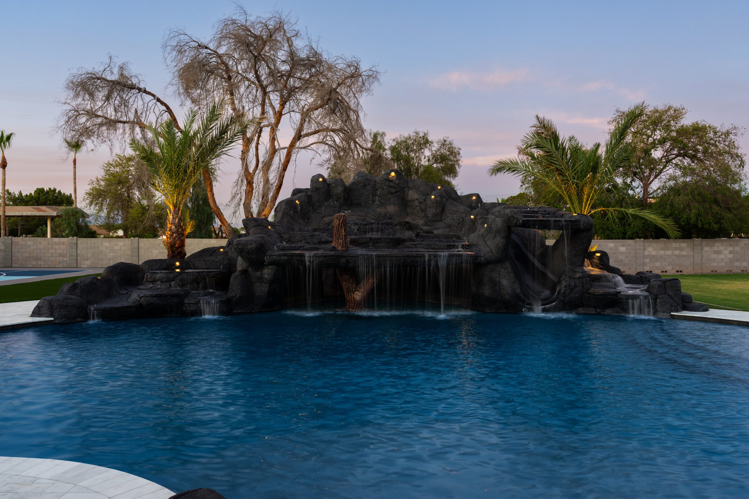 Rock waterfall structure and travertine pool deck in Gilbert, AZ