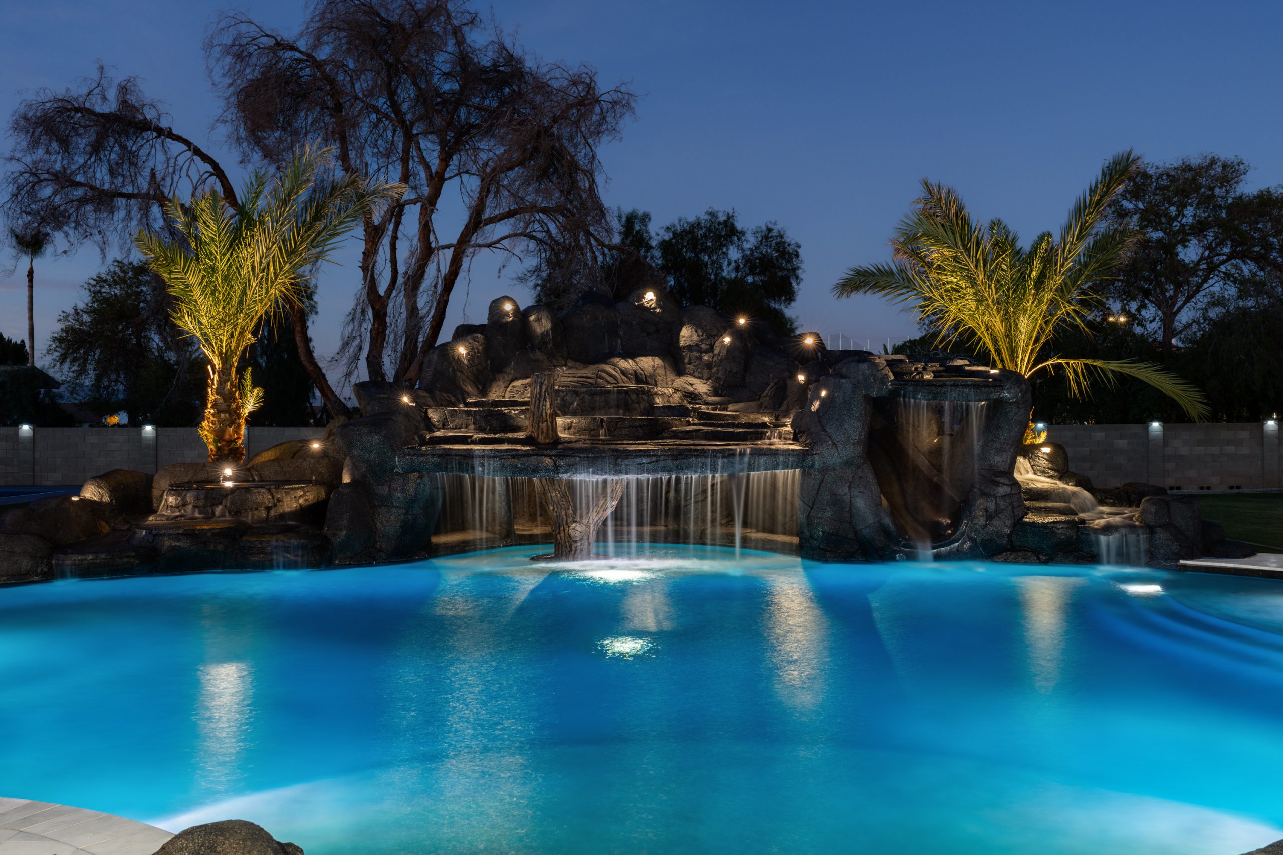 Custom rock waterfall pool at night in Gilbert, AZ