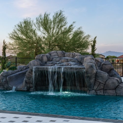 Rock waterfall and geometric pool at dusk in San Tan Valley, AZ