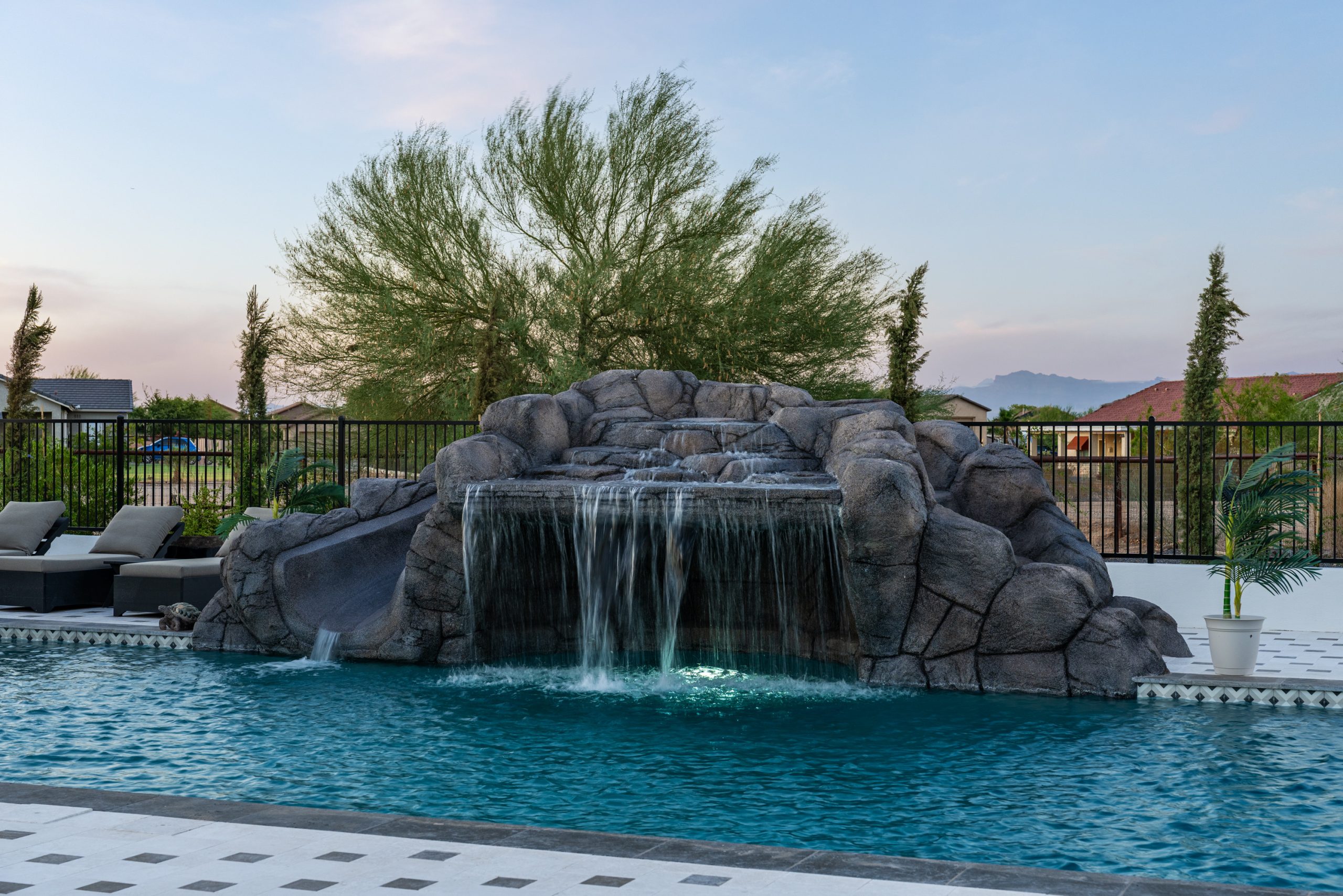 Rock waterfall and geometric pool at dusk in San Tan Valley, AZ
