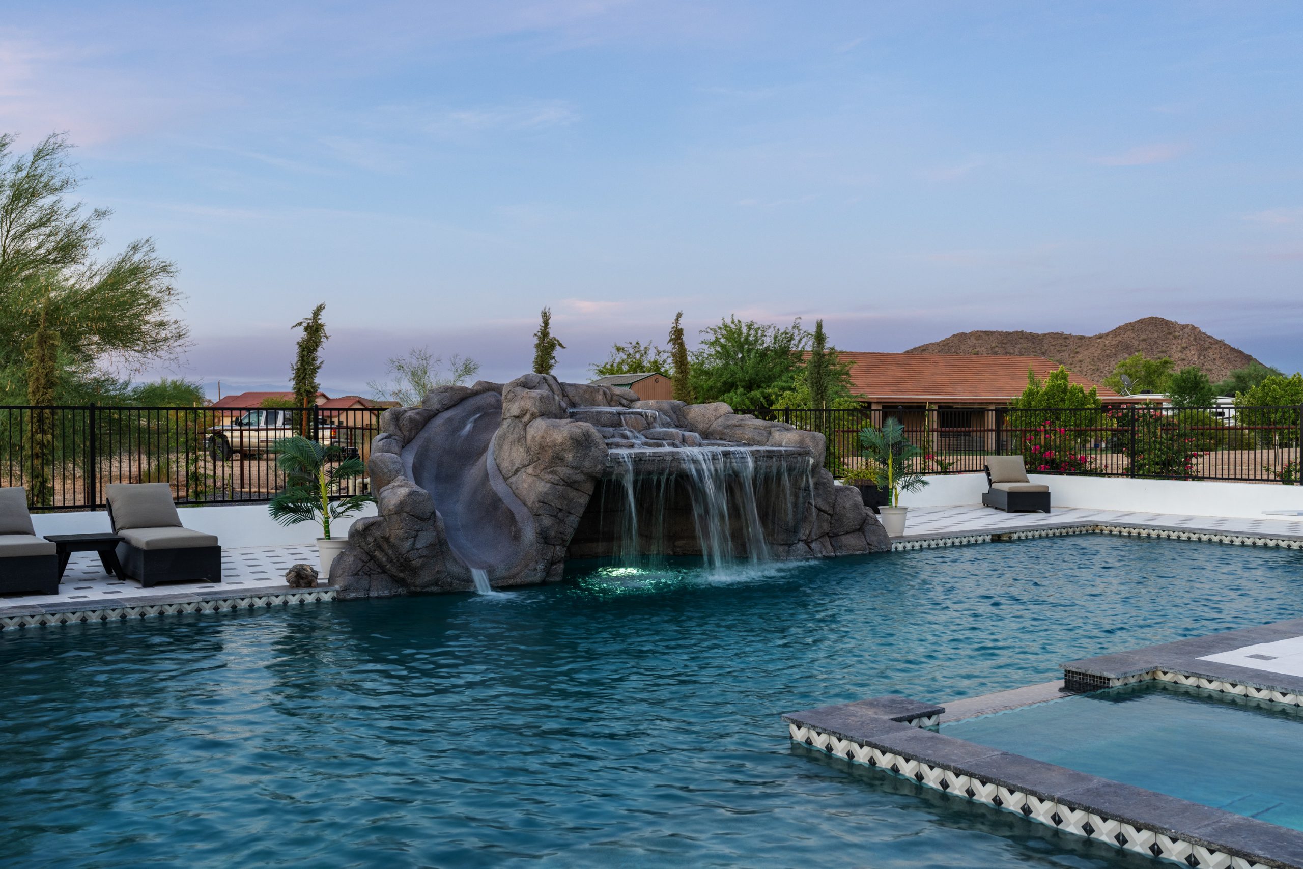 Rock waterfall grotto and pool with mountain views in San Tan Valley, AZ