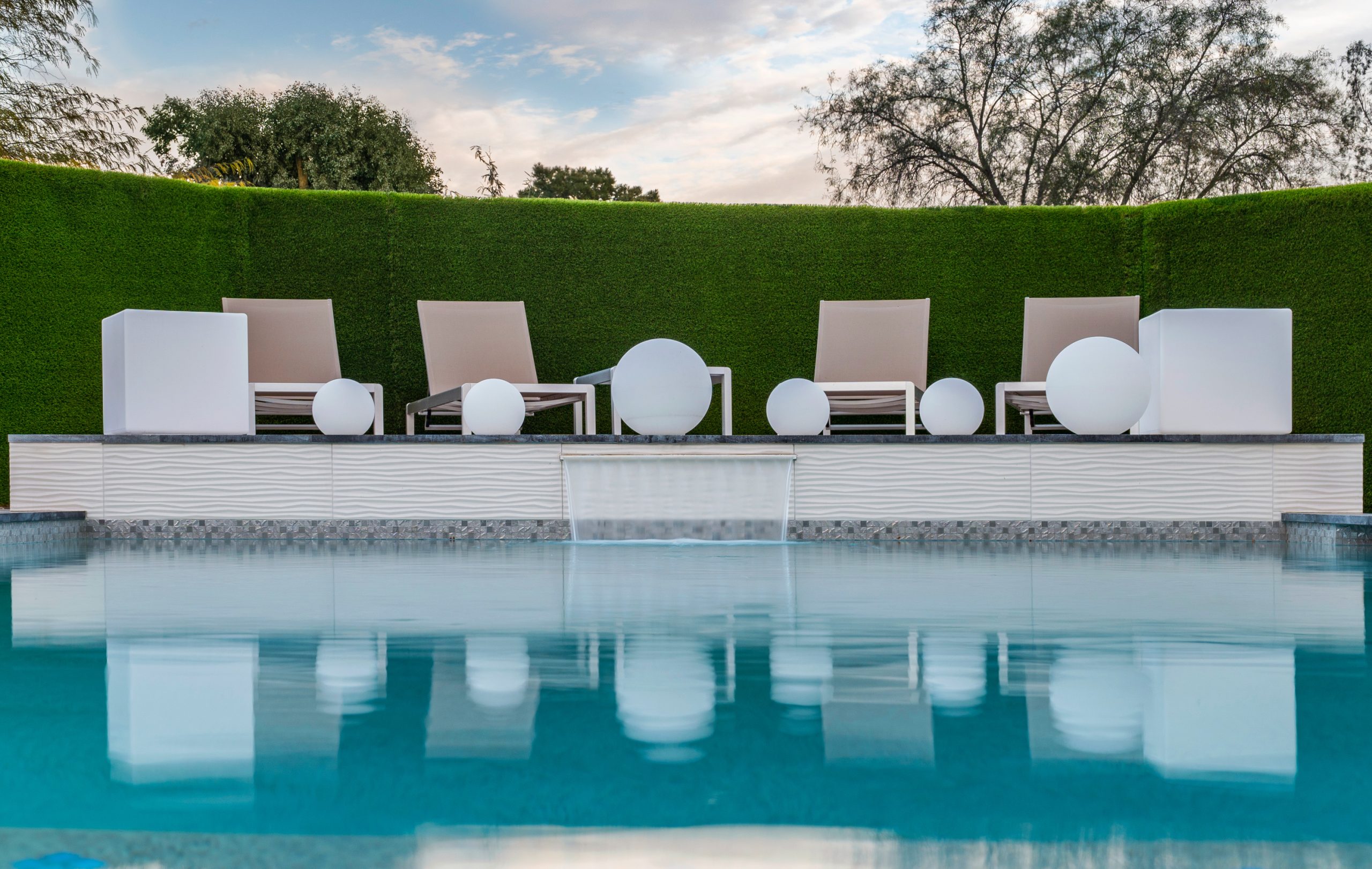 Modern pool with sheer descent and turf wall backdrop in Scottsdale, AZ