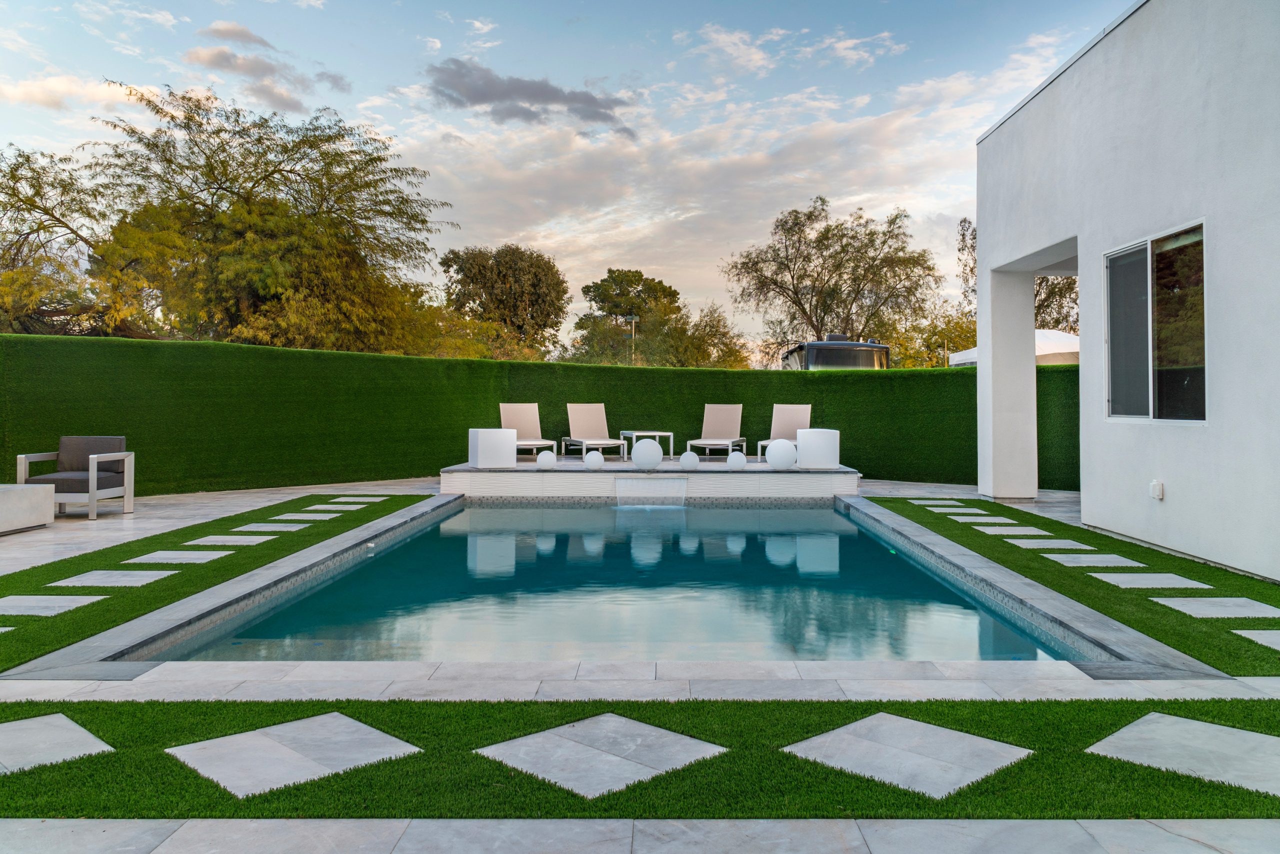 Rectangular pool with checkerboard paver and turf decking in Scottsdale, AZ