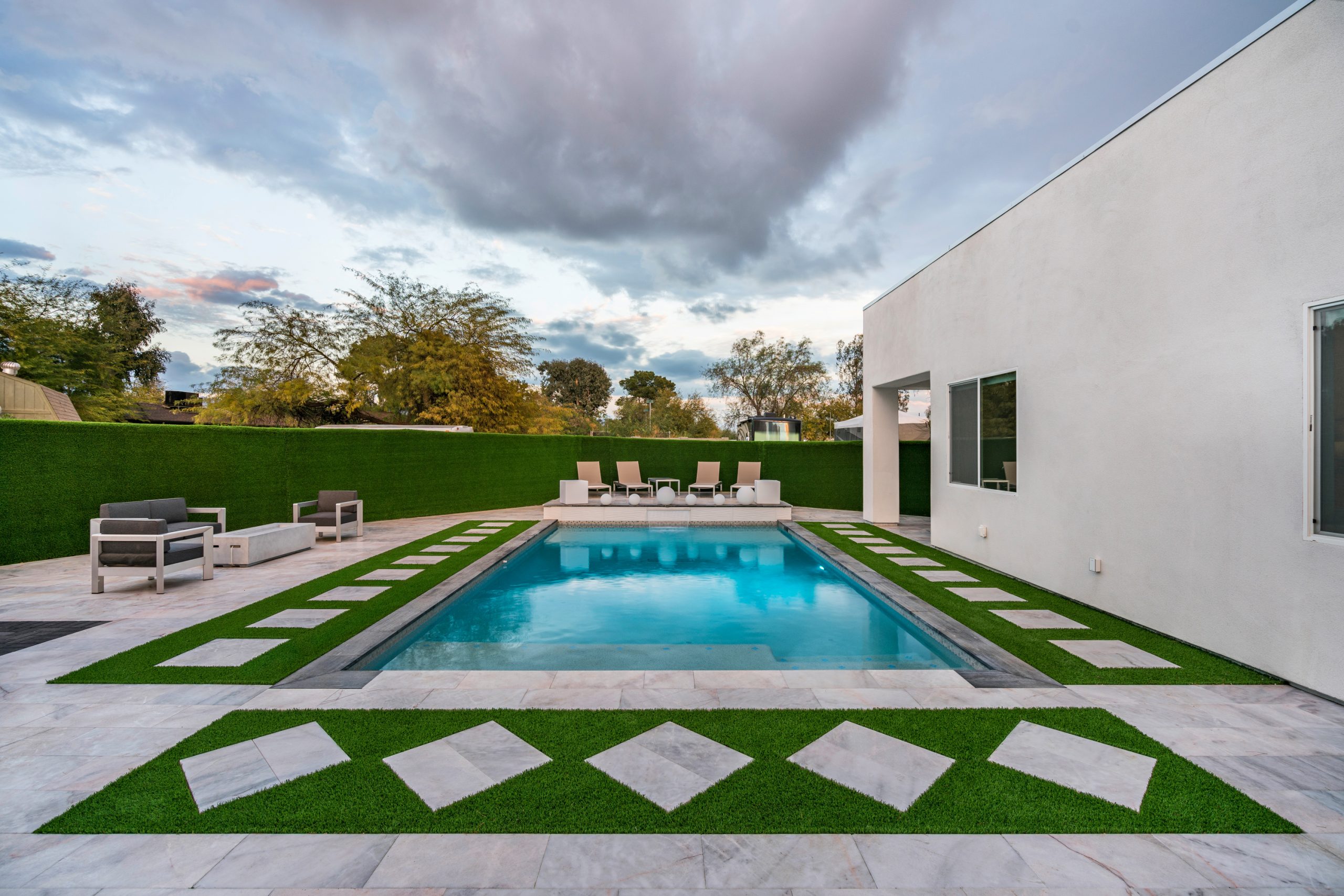 Modern geometric pool and covered patio at dusk in Scottsdale, AZ