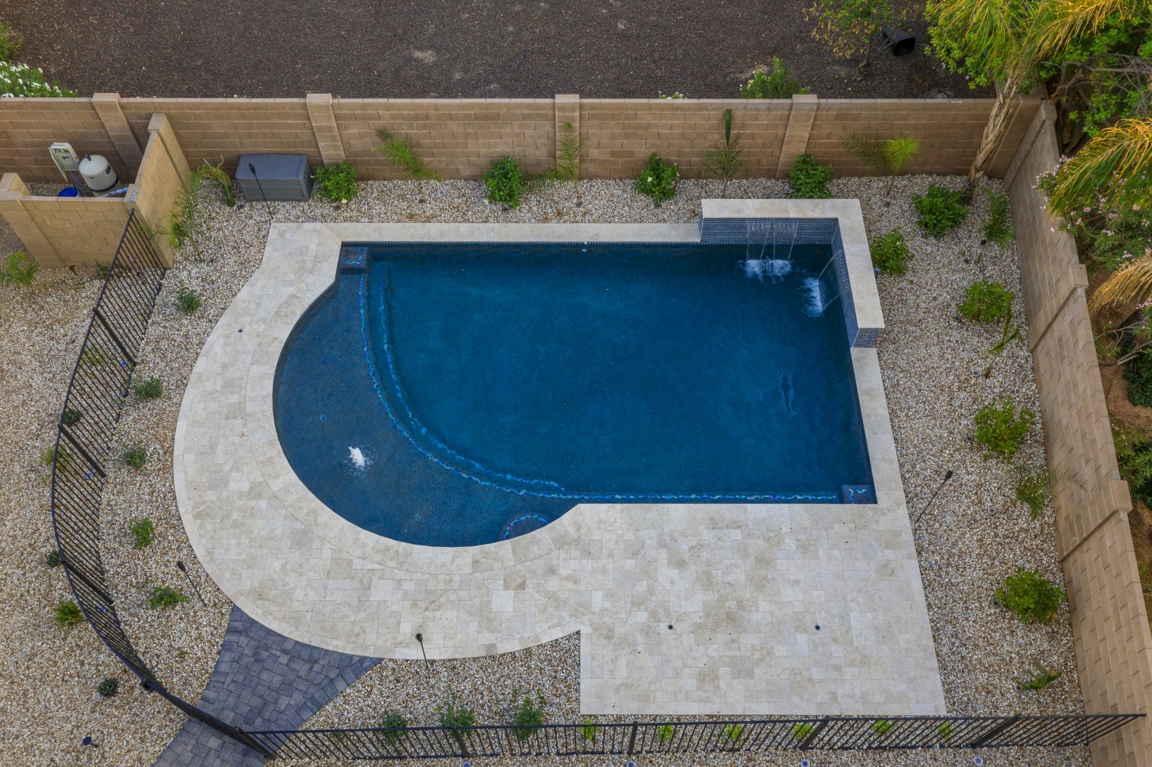Custom freeform pool with dual waterfalls and iridescent tile in Gilbert, AZ by Envy Pools