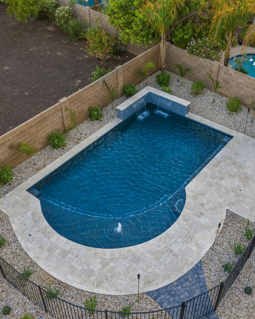 Custom freeform pool with dual waterfalls and iridescent tile in Gilbert, AZ by Envy Pools