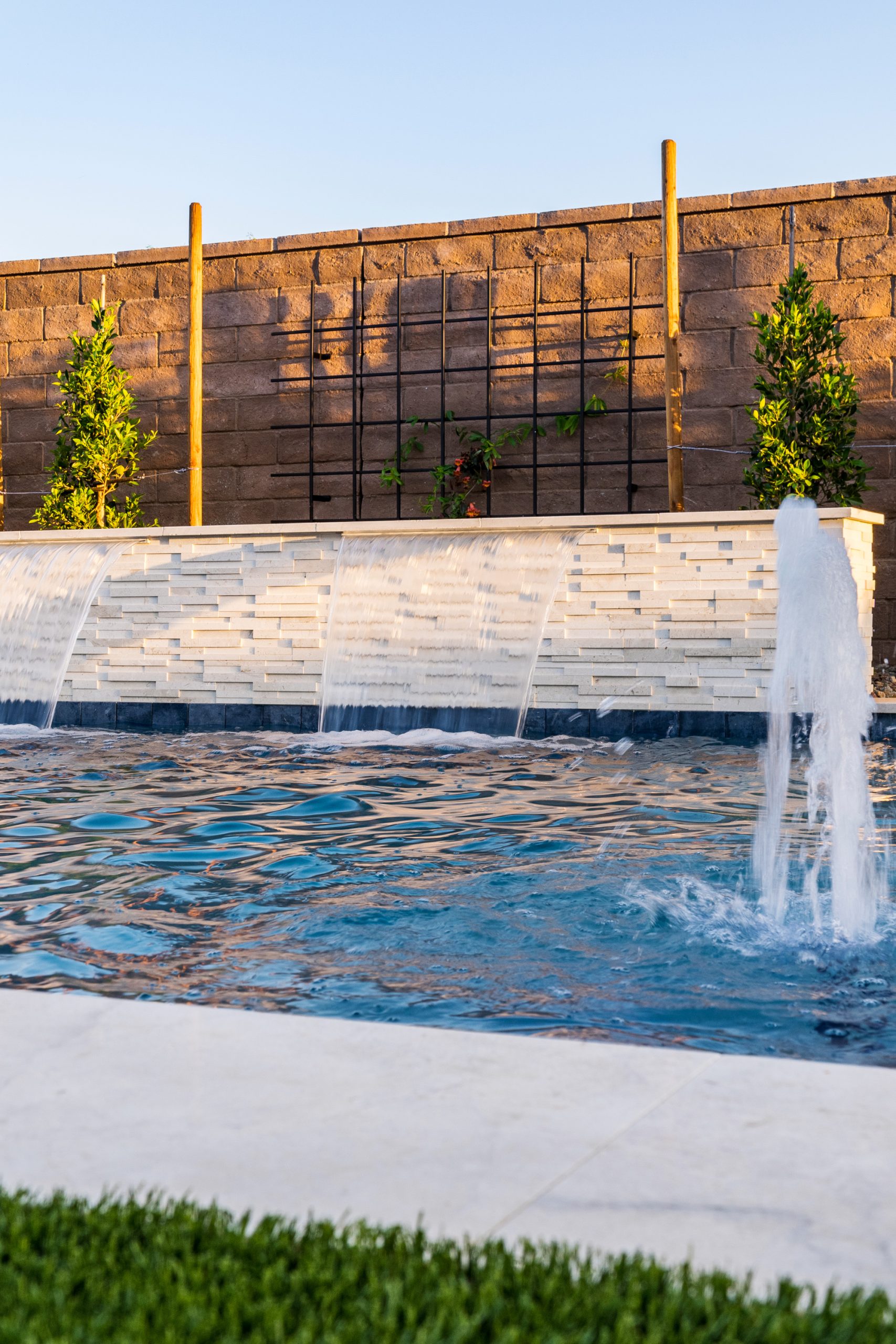 Deck jets arcing into a custom pool in Gilbert, AZ