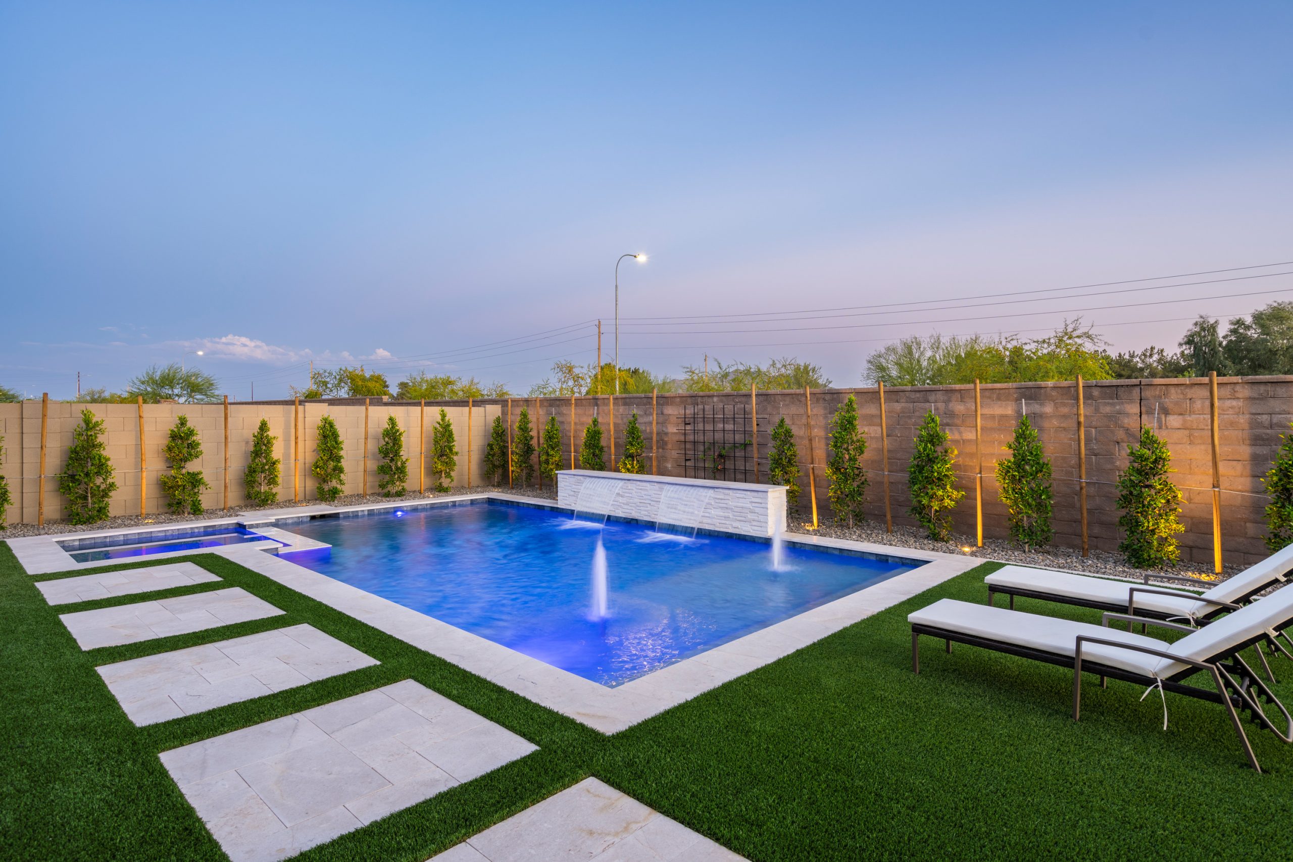 Geometric pool lit at dusk in a Gilbert, AZ backyard