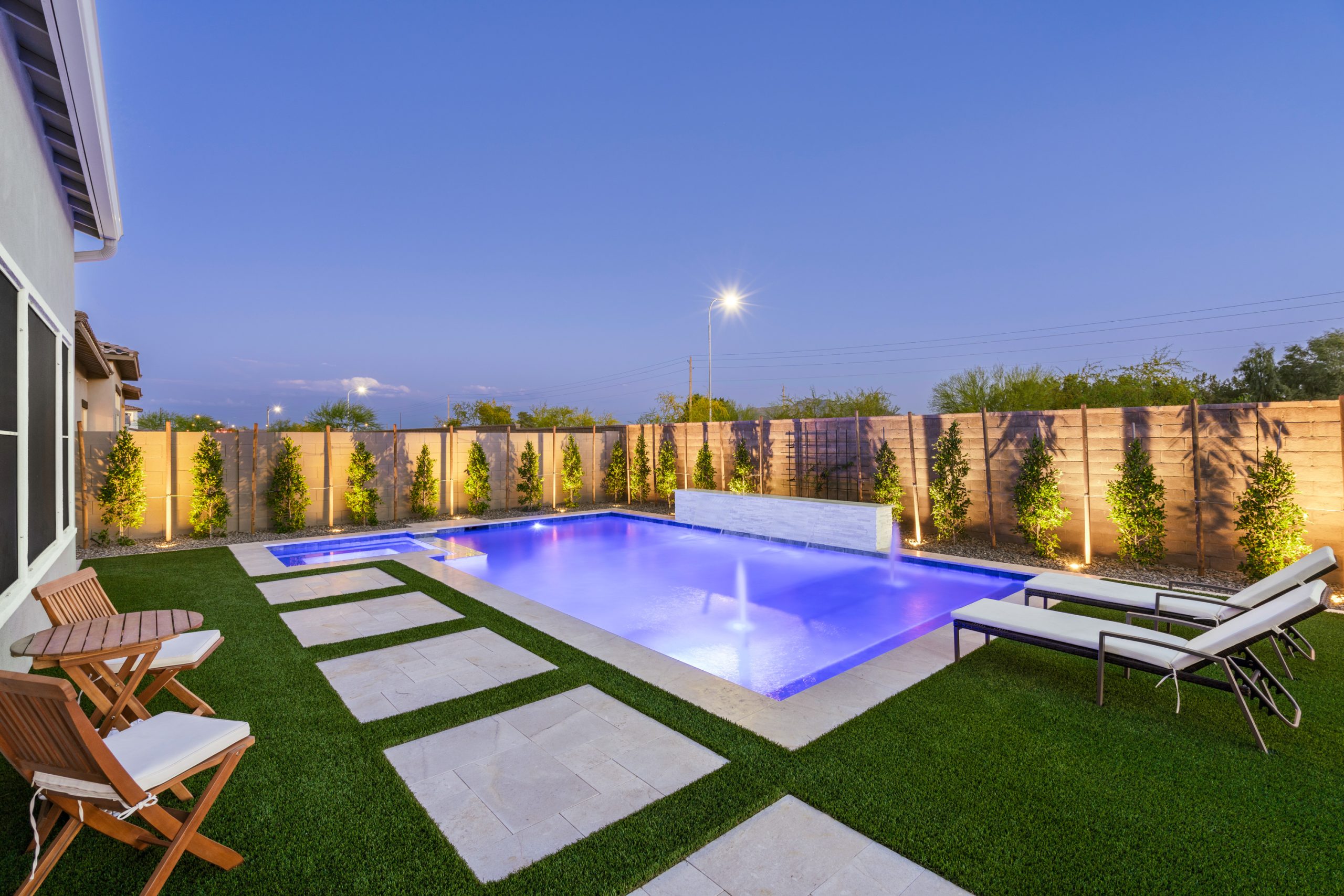 Backyard pool and covered patio lit at night in Gilbert, AZ